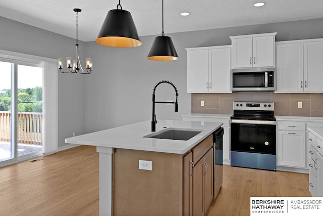 kitchen with tasteful backsplash, white cabinetry, a kitchen island with sink, and stainless steel appliances