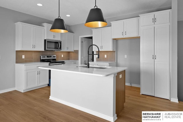 kitchen with white cabinets, tasteful backsplash, sink, and stainless steel appliances