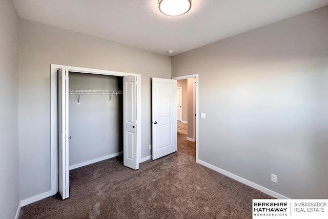 unfurnished bedroom featuring a closet and dark carpet