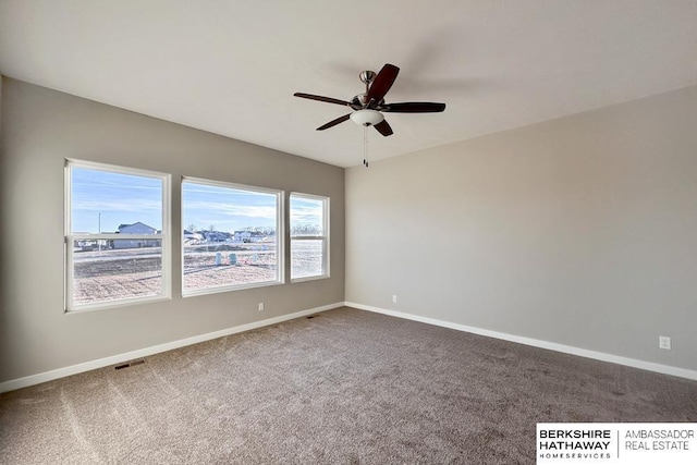 carpeted spare room featuring ceiling fan and a healthy amount of sunlight