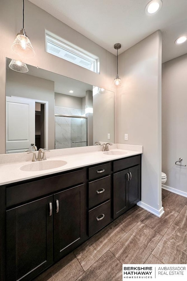 bathroom with toilet, walk in shower, and vanity