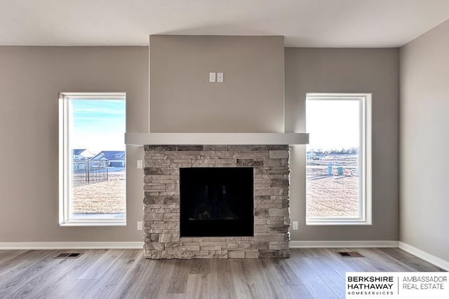 interior details with hardwood / wood-style flooring and a stone fireplace