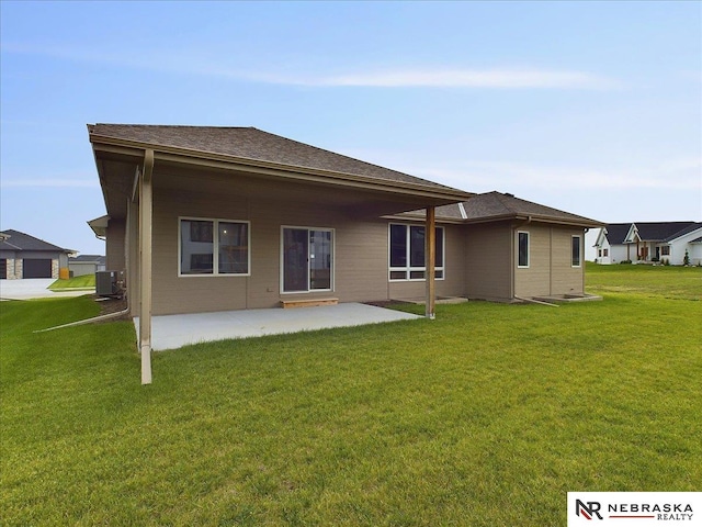 rear view of house with cooling unit, a lawn, and a patio