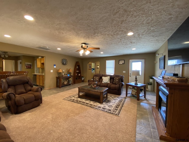 living room with arched walkways, a glass covered fireplace, recessed lighting, and a ceiling fan