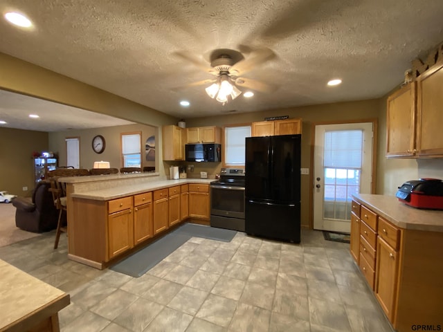 kitchen featuring black appliances, a ceiling fan, recessed lighting, a peninsula, and light countertops