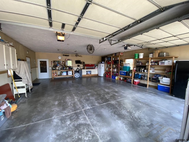 garage featuring a garage door opener and freestanding refrigerator