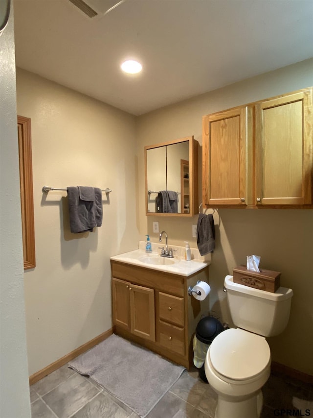 bathroom featuring tile patterned floors, baseboards, toilet, and vanity