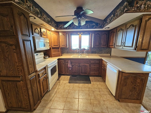 kitchen with sink, white appliances, light tile patterned floors, a textured ceiling, and kitchen peninsula