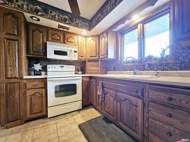 kitchen with white appliances, sink, decorative backsplash, and light tile patterned floors