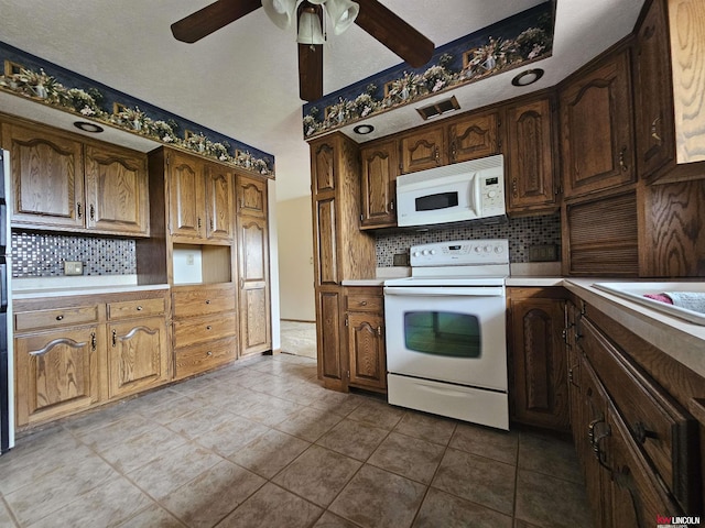 kitchen with tasteful backsplash, ceiling fan, tile patterned flooring, and white appliances