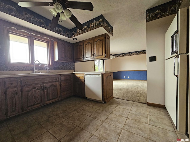 kitchen with light tile patterned flooring, sink, white appliances, ceiling fan, and a textured ceiling