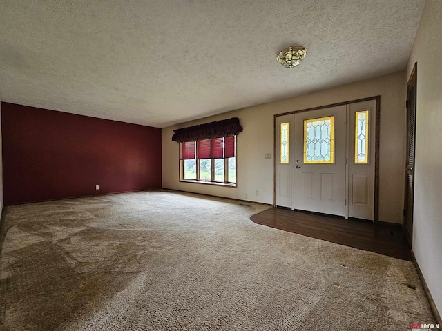 carpeted entrance foyer featuring a textured ceiling