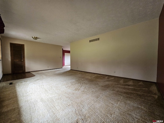 carpeted empty room featuring a textured ceiling