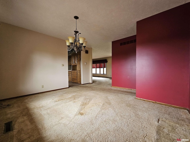 interior space featuring carpet floors, a textured ceiling, and a chandelier