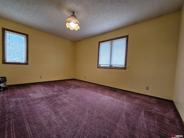 carpeted spare room with a textured ceiling