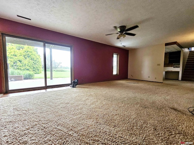 unfurnished living room with carpet floors, a textured ceiling, and ceiling fan