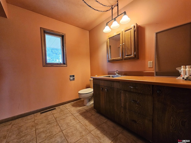 bathroom featuring vanity, toilet, tile patterned flooring, and a textured ceiling