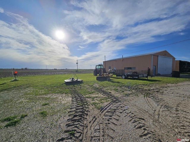 view of yard featuring an outbuilding and a rural view