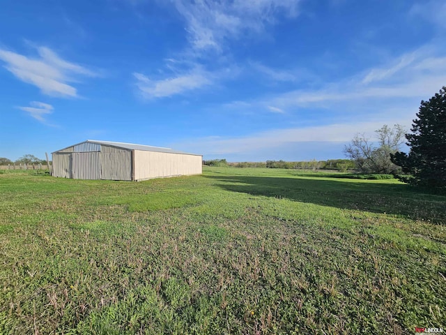 view of yard with an outdoor structure and a rural view