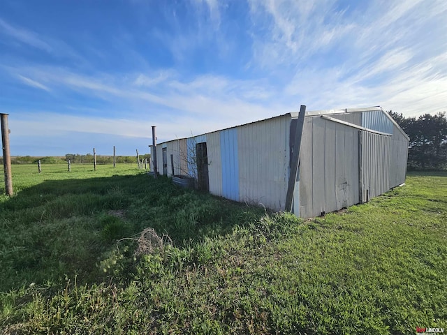 view of outdoor structure with a yard and a rural view