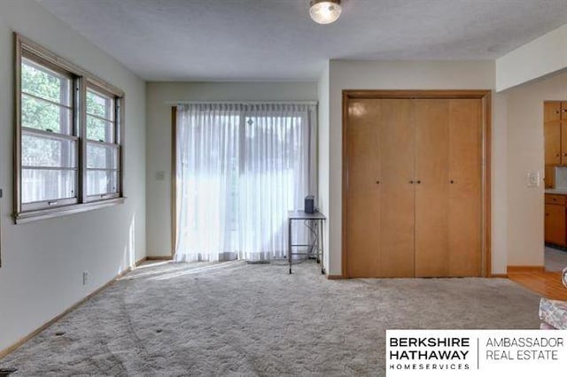 unfurnished bedroom featuring light colored carpet and a closet