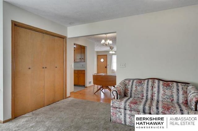 living room featuring light colored carpet and a notable chandelier