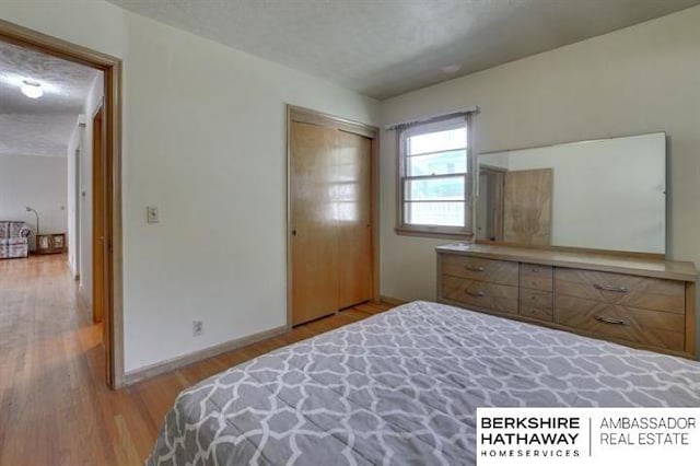 bedroom featuring a closet, a textured ceiling, and light wood-type flooring