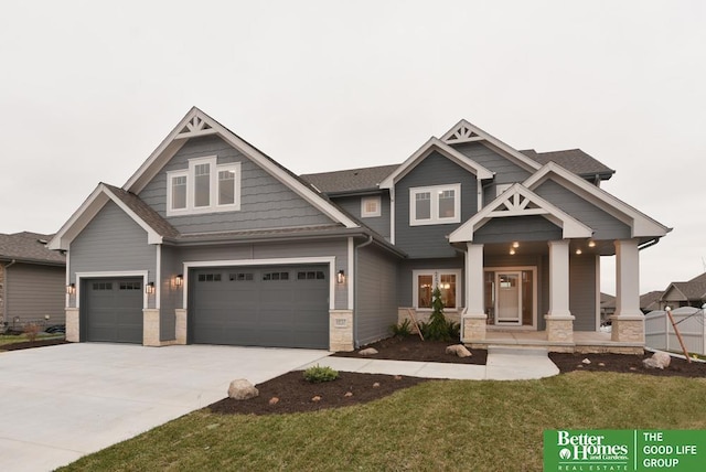 craftsman house featuring a porch, a garage, and a front lawn