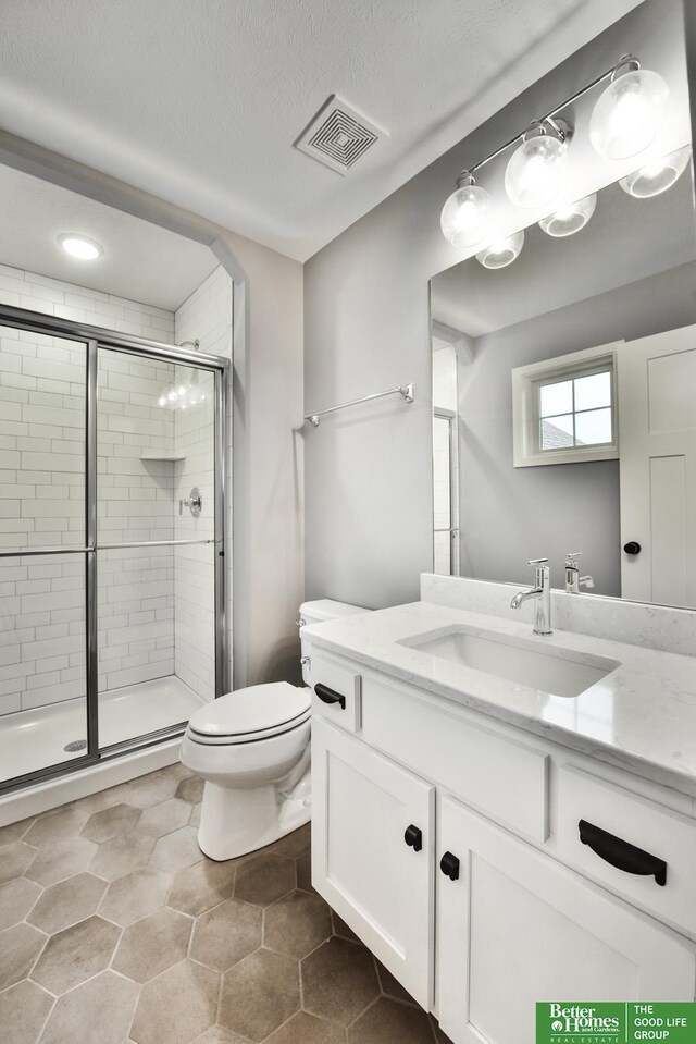 19058 Camelback Cir, Gretna, NE 68136 - bathroom featuring vanity, a textured ceiling, a shower with door, and toilet