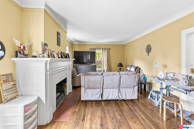 living room with hardwood / wood-style flooring, a brick fireplace, and ornamental molding