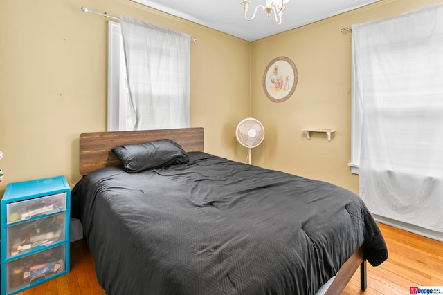 bedroom with wood-type flooring and a chandelier