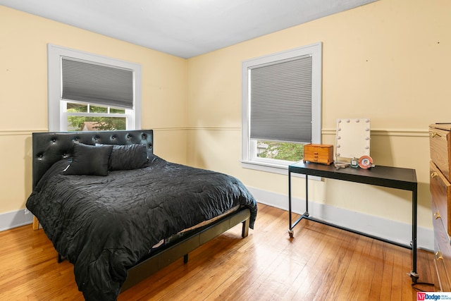 bedroom with multiple windows and light wood-type flooring