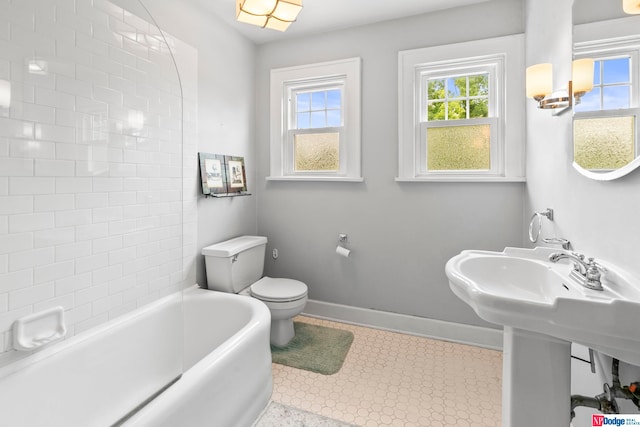 bathroom featuring toilet, tile patterned flooring, and a bathtub