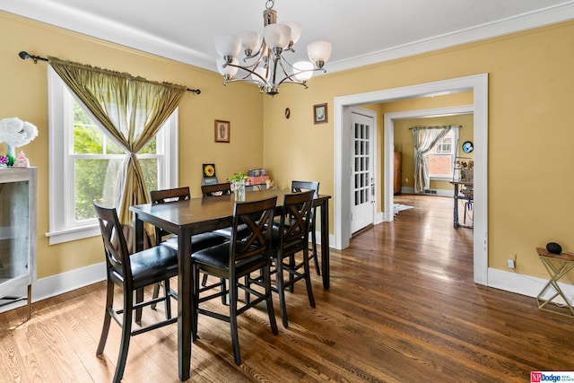 dining room featuring ornamental molding, an inviting chandelier, and hardwood / wood-style flooring