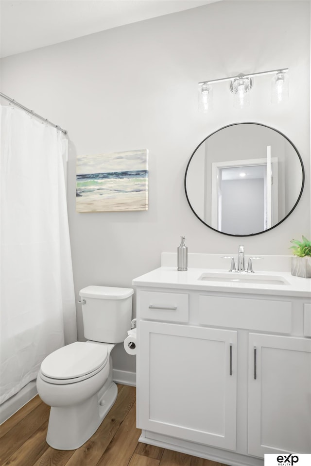 bathroom with hardwood / wood-style flooring, toilet, and vanity