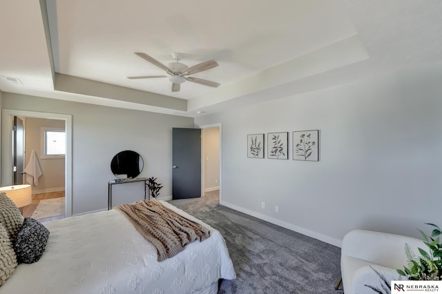 bedroom featuring carpet, connected bathroom, ceiling fan, and a raised ceiling