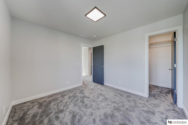 unfurnished bedroom featuring light colored carpet, a closet, and a walk in closet