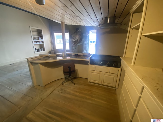 kitchen featuring wall chimney range hood, wood ceiling, vaulted ceiling, a peninsula, and wood finished floors