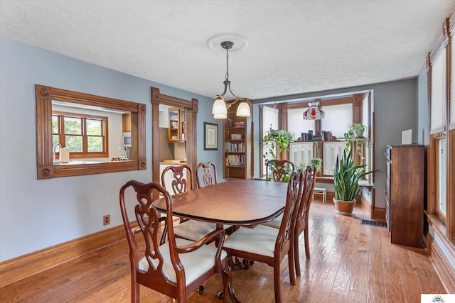 dining room with hardwood / wood-style flooring and a textured ceiling