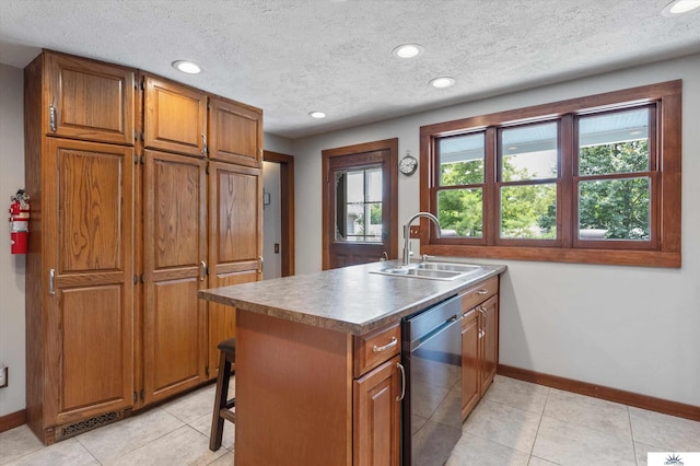 kitchen featuring sink, light tile patterned floors, stainless steel dishwasher, a textured ceiling, and a center island