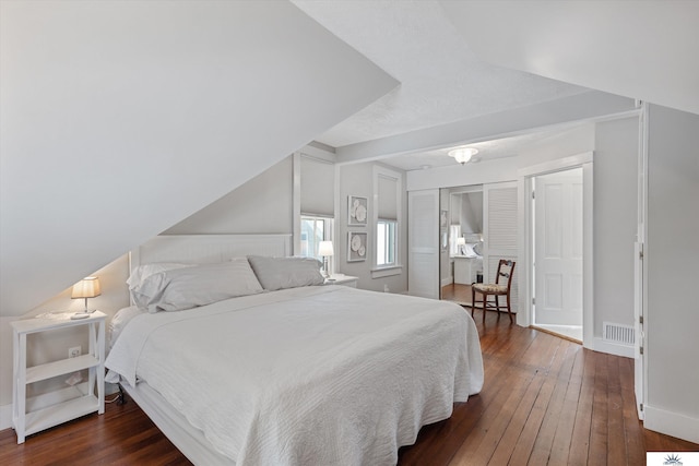 bedroom with dark wood-type flooring and a closet