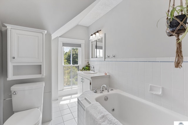 bathroom with tiled tub, tile patterned floors, toilet, and vanity