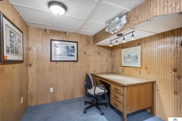 home office with wood walls, carpet floors, and a paneled ceiling