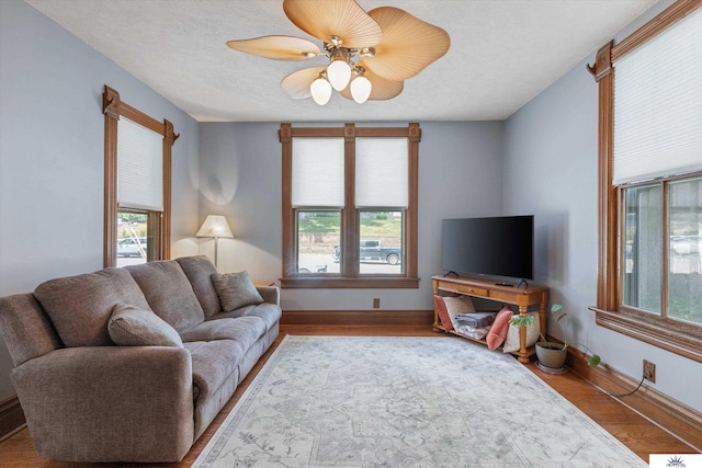 living room with plenty of natural light, ceiling fan, a textured ceiling, and hardwood / wood-style flooring