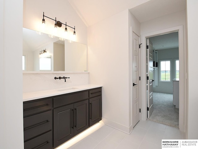 bathroom featuring tile patterned floors, vanity, and lofted ceiling