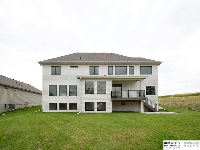 rear view of property featuring cooling unit and a yard