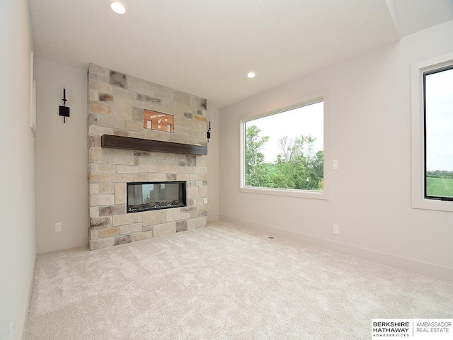 unfurnished living room with light carpet and a fireplace