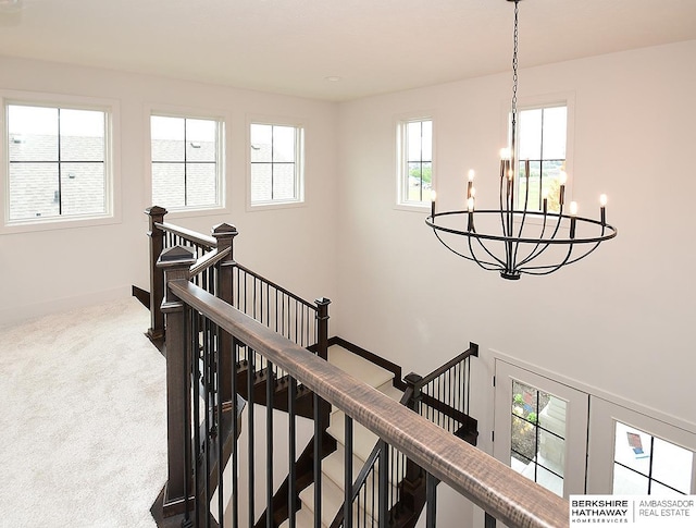 stairs featuring carpet and a chandelier