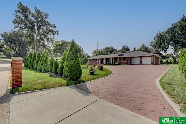 single story home featuring a garage and a front lawn