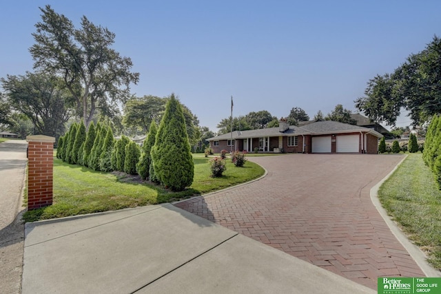 ranch-style home with a front yard, decorative driveway, brick siding, and a garage